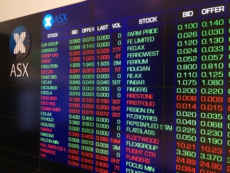 ASX digital board with stocks listed in red and green