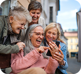 Group of older ladies looking at a mobile phone