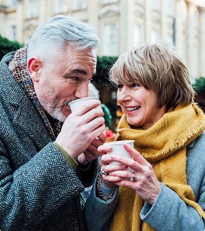 Older couple drinking warm drinks in cold weather