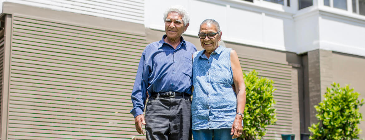 Couple standing together outside of a house