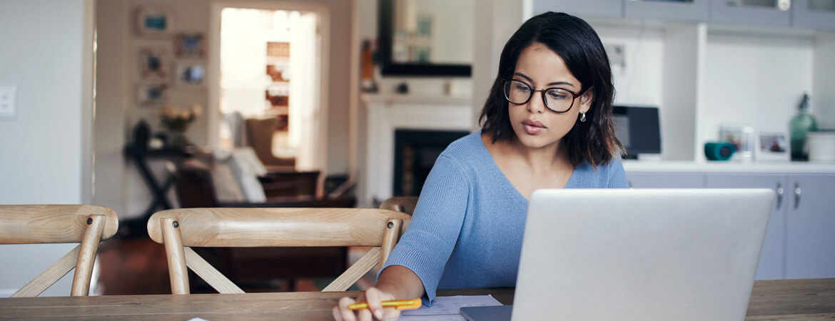 young woman at home doing finances on laptop