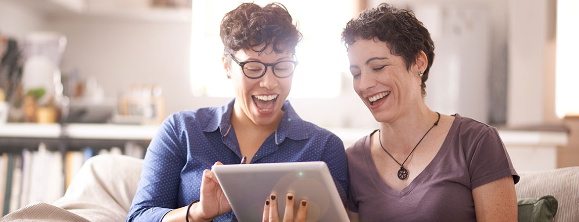 two happy people looking at a tablet device