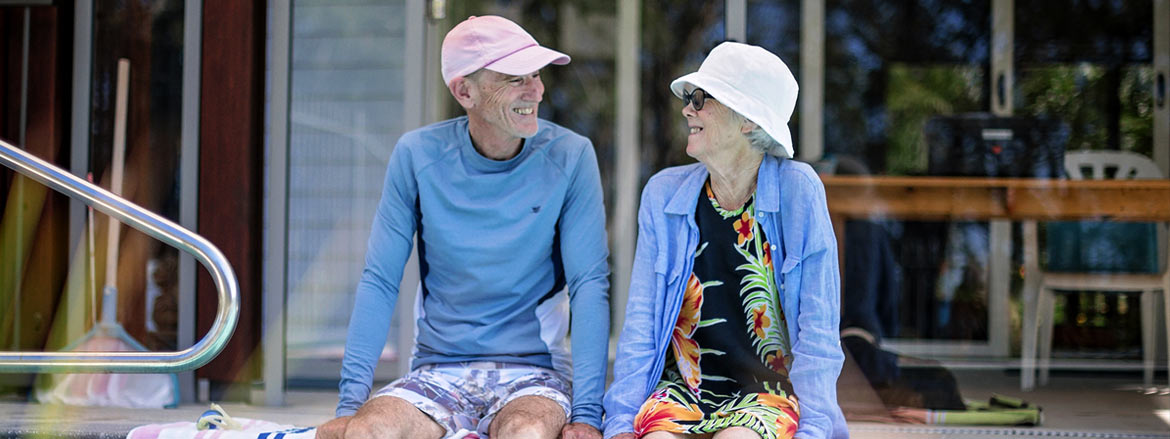 Retired couple sitting by a pool