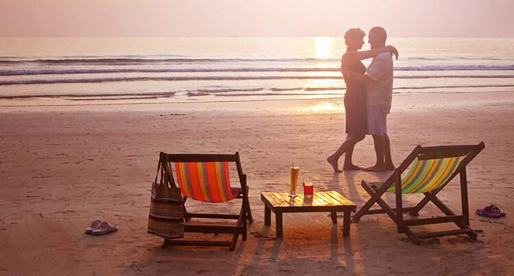 Couple in each others arms on the beach waiting for the sunset