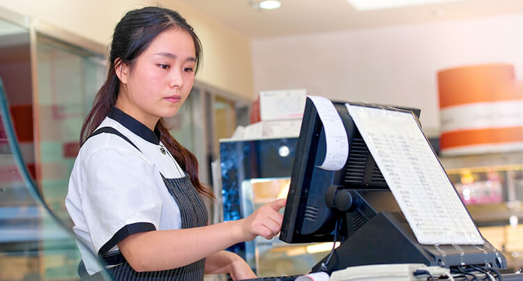 Young worker entering information into the cash register